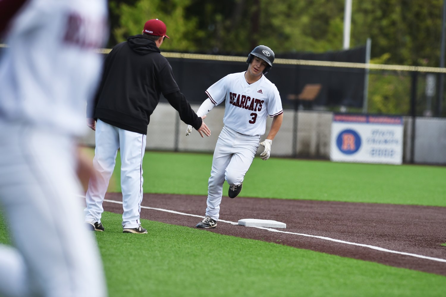 Evan Stajduhar rounds third base and heads for home as his teammates mob out of the dugout to congratulate him after swatting a home run in the second inning against Mark Morris in the 2A District 4 tournament May 14 in Ridgefield.